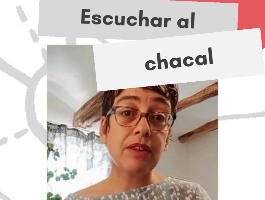 Una mujer con pelo corto y gafas habla en un interior; sobre ella se lee "Escuchar al chacal", ilustrando qué es la comunicación noviolenta.
